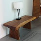 Haussmann Natural Edge solid wood bench in Walnut finish in an entryway with a lamp on top